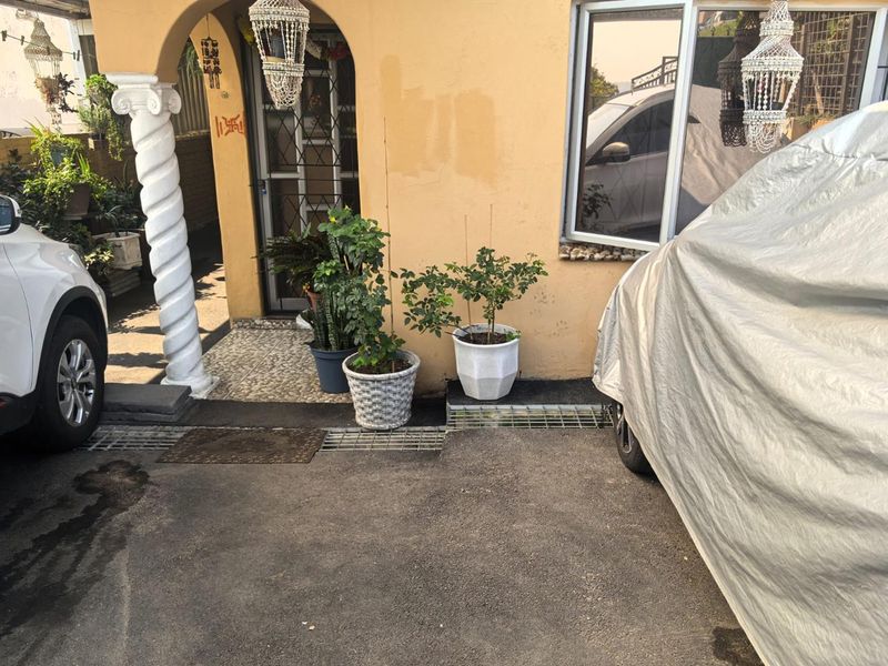 Front entrance area featuring an arched doorway with a decorative column and pebble stone flooring, providing access to the main residence.