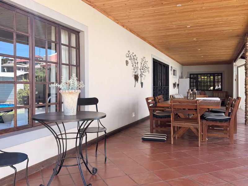 Spacious covered patio featuring a warm timber-clad ceiling, recessed lighting, and durable terracotta floor tiles, perfect for outdoor dining and relaxation.