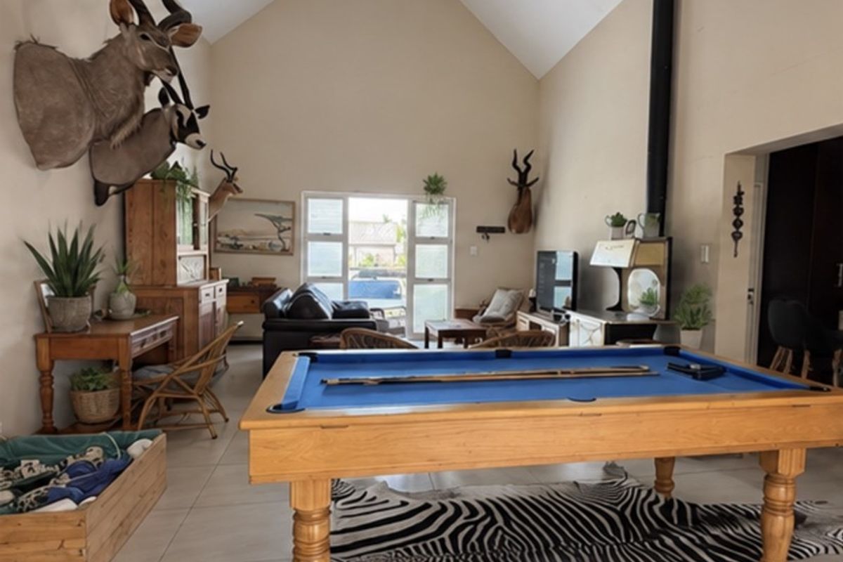 Spacious living area featuring a high vaulted ceiling, tiled flooring, and a prominent freestanding fireplace, offering a versatile open-plan layout.