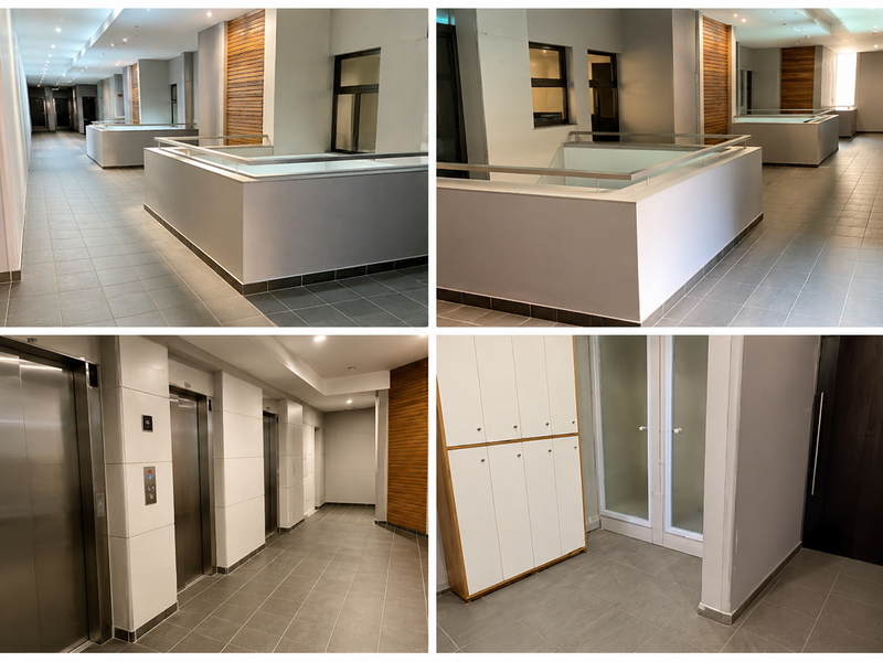 A modern apartment building hallway featuring tiled floors, recessed lighting, elevator access, and decorative timber wall paneling.