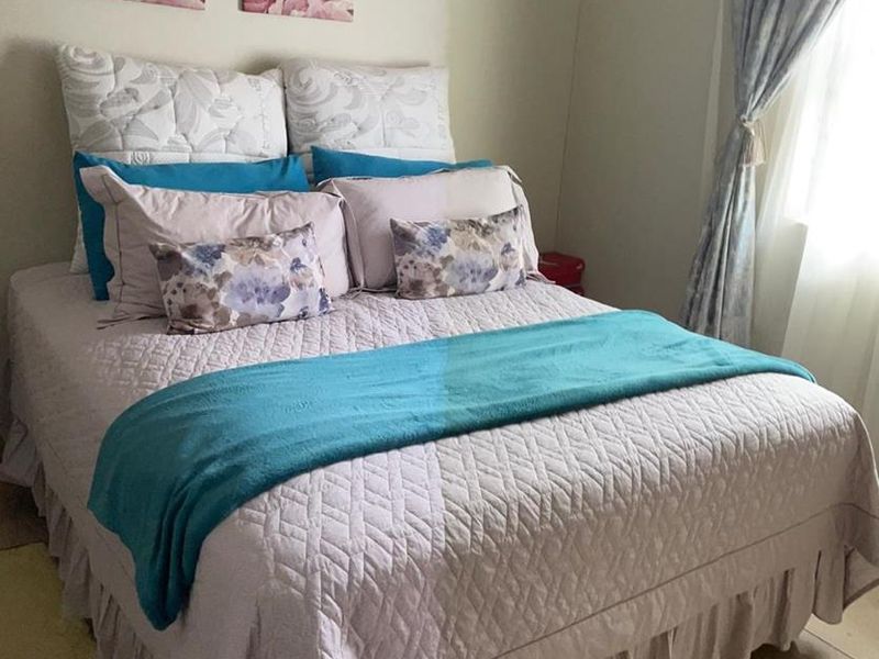 A bedroom featuring tiled flooring and natural light from a side window.