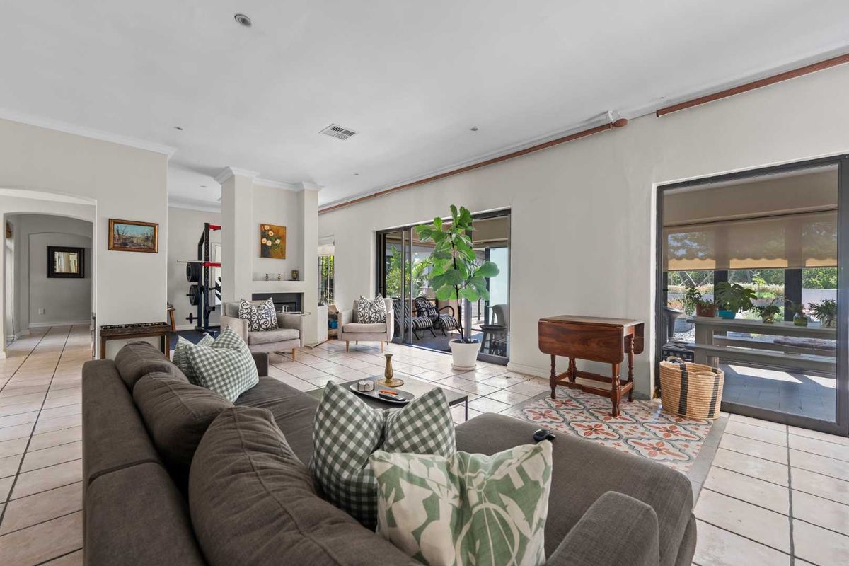 Spacious living room featuring tiled flooring, a fireplace, and large sliding glass doors that provide seamless access to the outdoor patio area.