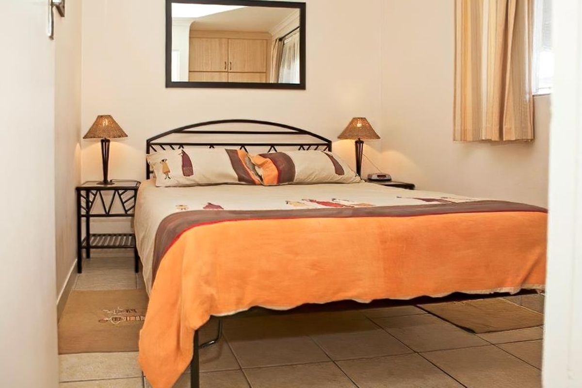 A functional bedroom featuring tiled flooring and a built-in cupboard, providing a practical and comfortable sleeping space.
