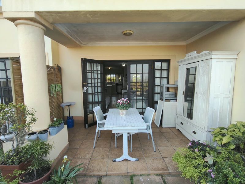 A covered patio area featuring tiled flooring and access to the interior through classic french doors.