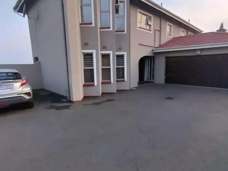 Front exterior view of a multi-story residential property featuring a paved driveway, double garage, and tiled roof.