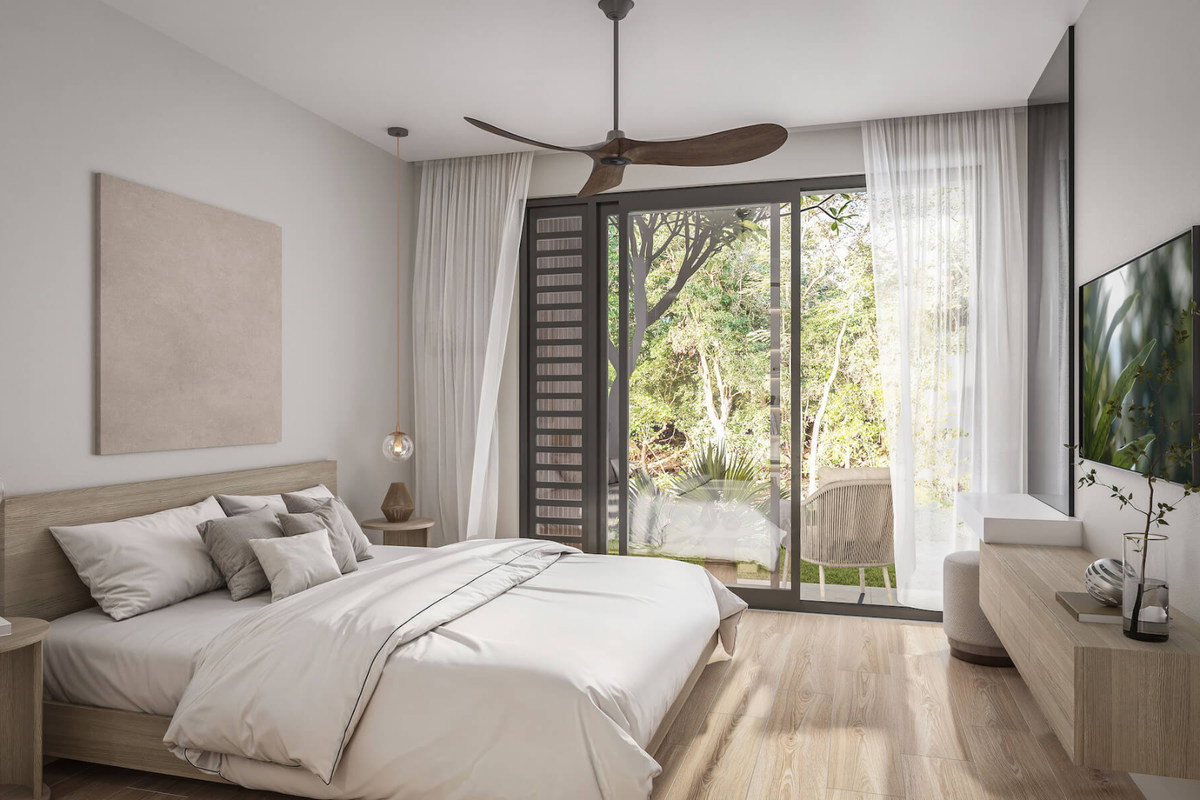 A modern, well-lit bedroom featuring wood-look flooring, a ceiling fan, and large sliding glass doors that open to a private garden view.
