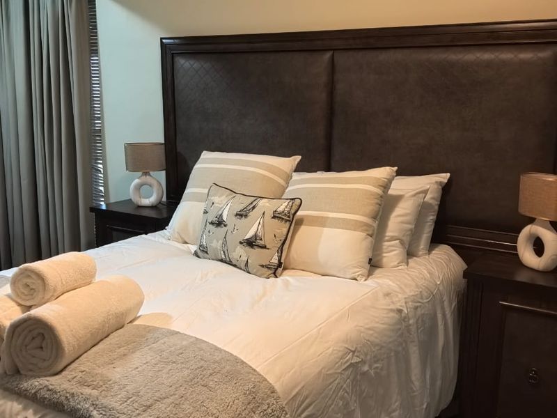 A well-maintained bedroom featuring crown molding and neutral carpeted flooring, providing a comfortable and classic living space.