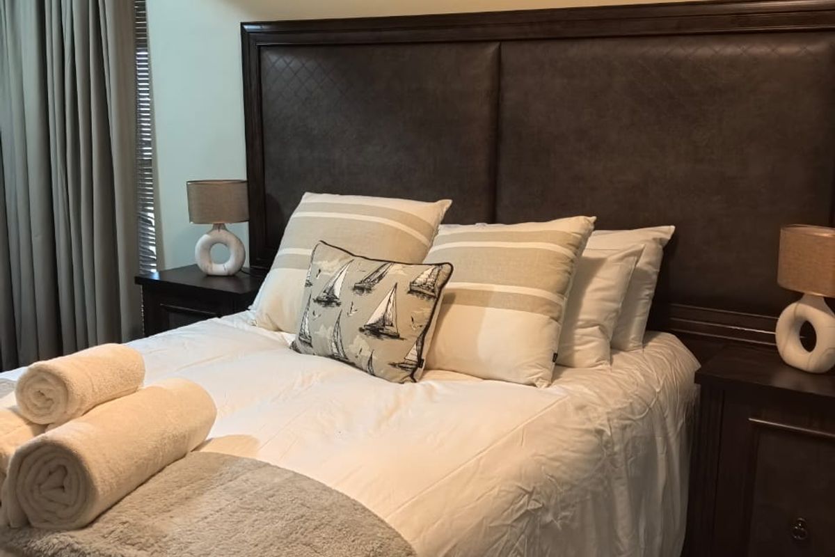 A well-maintained bedroom featuring crown molding and neutral carpeted flooring, providing a comfortable and classic living space.