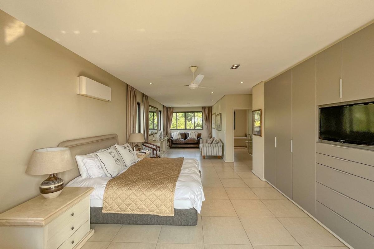 Spacious bedroom featuring large built-in cupboards, tiled flooring, recessed ceiling lighting, a ceiling fan, and an integrated air conditioning unit.