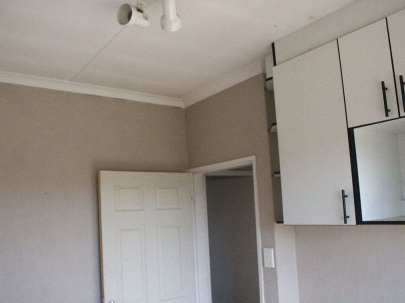 A view of a kitchen area featuring built-in white cabinetry and neutral wall finishes.