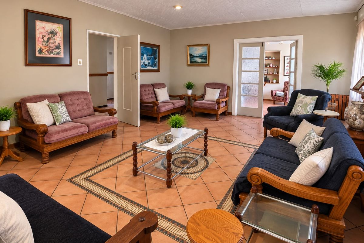 Spacious living room featuring terracotta tiled flooring with decorative inlay, recessed lighting, and access to adjacent rooms through internal doors.