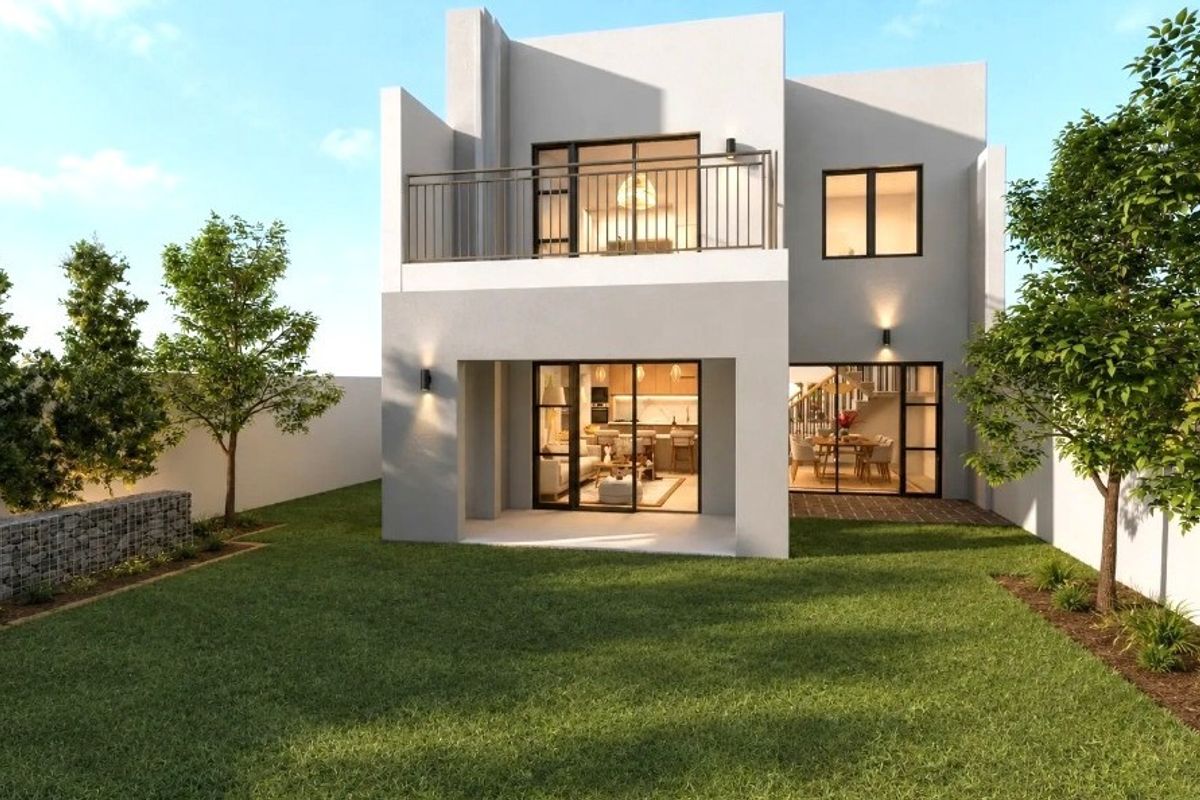 Rear view of a modern two-story house featuring a private garden, a ground-floor patio, and an upper-level balcony with metal railings.