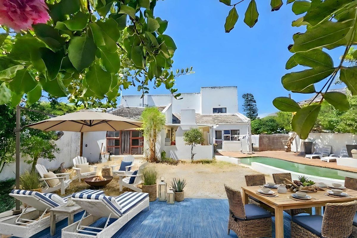 Spacious rear garden featuring a swimming pool, paved patio area, and established landscaping, providing a private outdoor entertainment space.