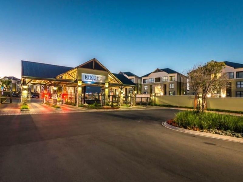 The main entrance and security gatehouse of the Kikuyu apartment complex, featuring modern architecture, paved access, and well-maintained landscaping.