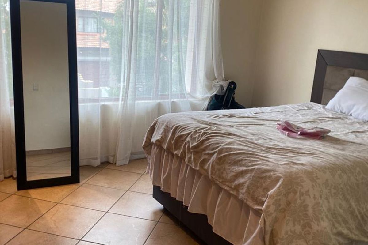 A bedroom featuring tiled flooring, large windows allowing natural light, and recessed ceiling lighting.