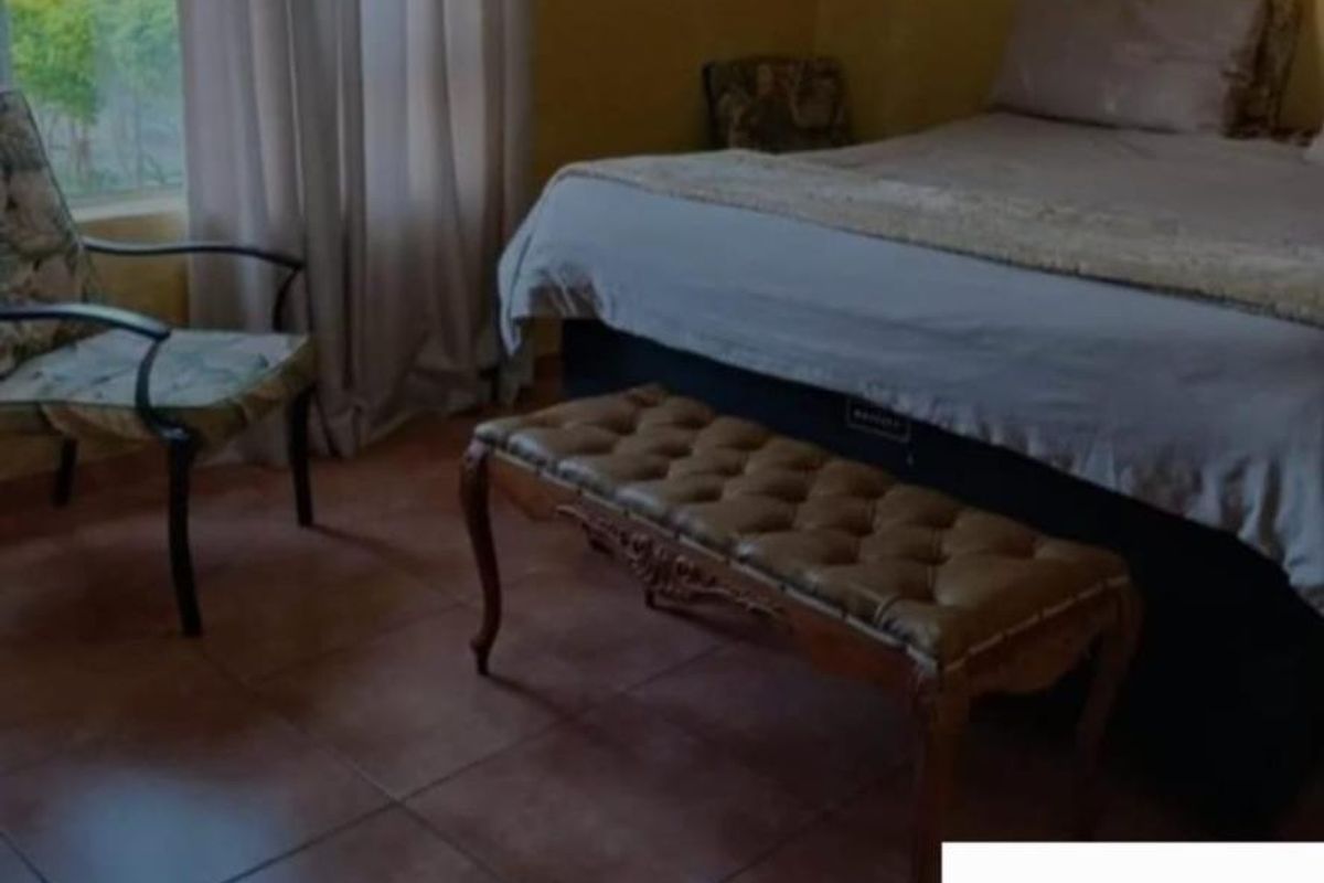 A bedroom featuring tiled flooring and natural light from a window.