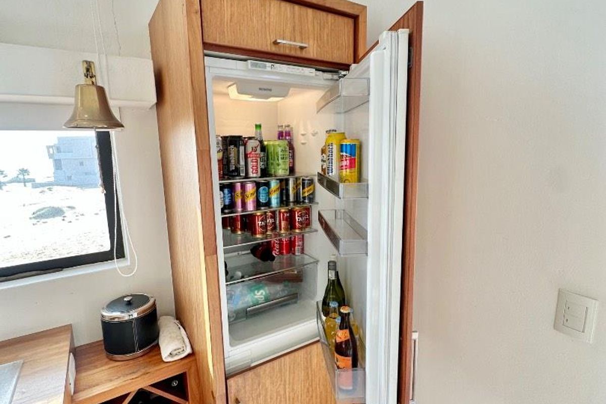 A kitchen area featuring custom wooden cabinetry with an integrated refrigerator and a built-in wine rack, set against tiled flooring.