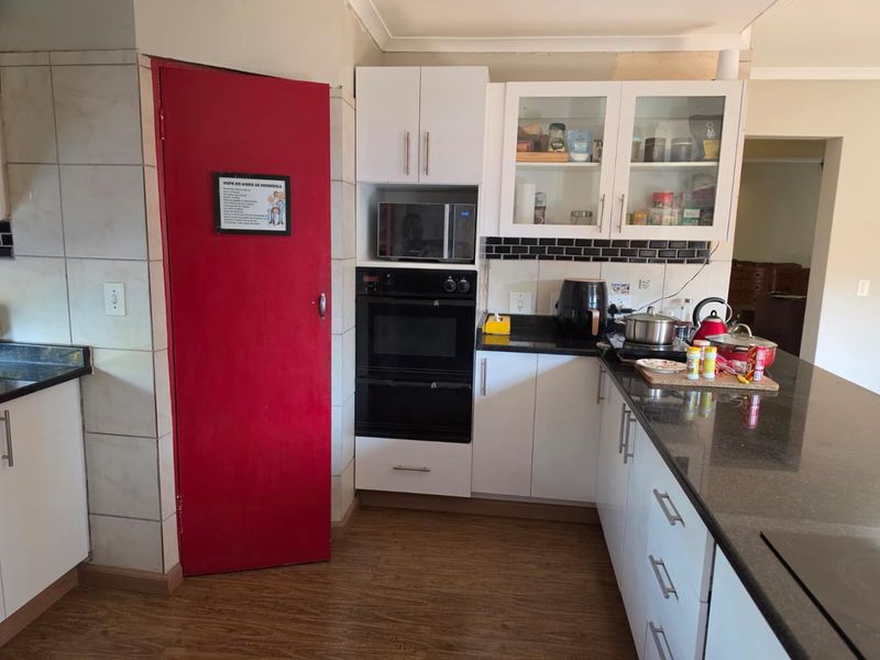 A functional kitchen featuring granite countertops, a subway tile backsplash, built-in oven, and microwave, with ample upper and lower cabinetry storage.