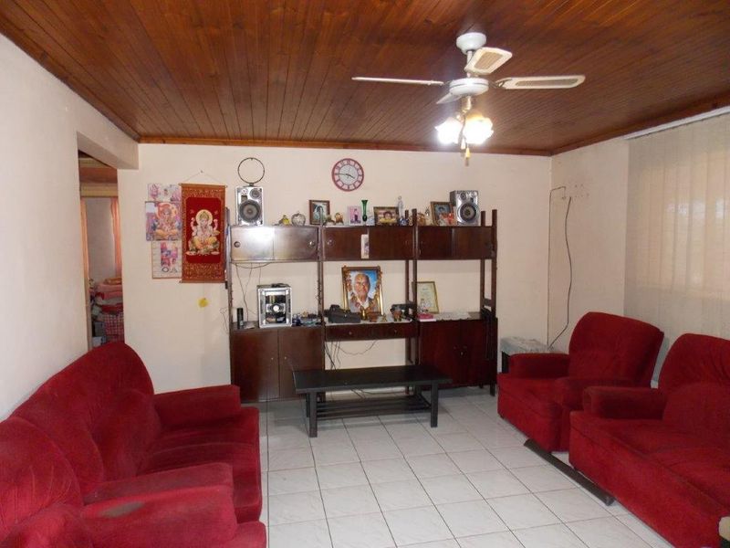 A living room featuring a timber tongue and groove ceiling, ceiling fan, and ceramic tiled flooring.