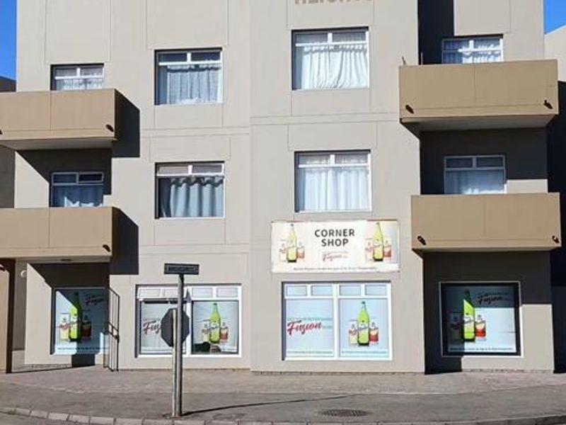 Front elevation of Edelweiss Heights apartment building featuring a multi-story facade with balconies and ground-floor commercial space.