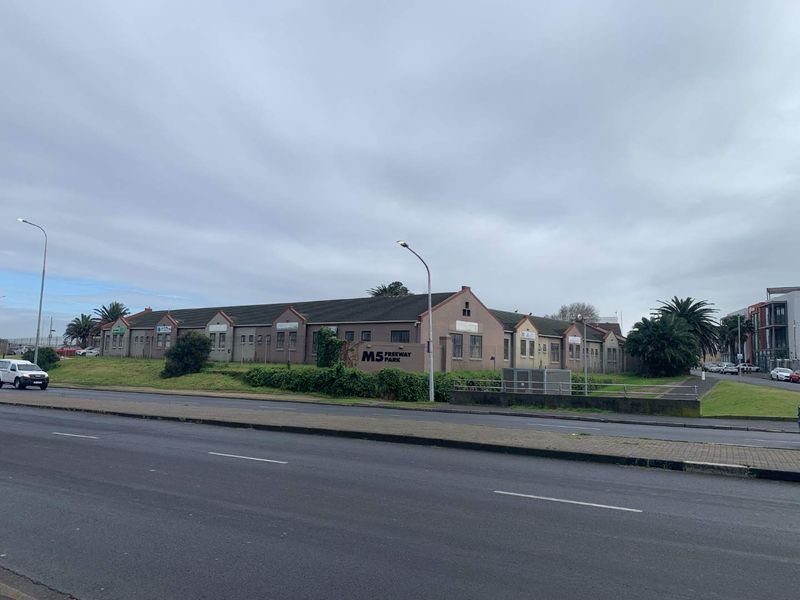 Exterior view of the M5 Freeway Park commercial complex, featuring a long single-story building with a tiled roof and prominent street-facing signage.