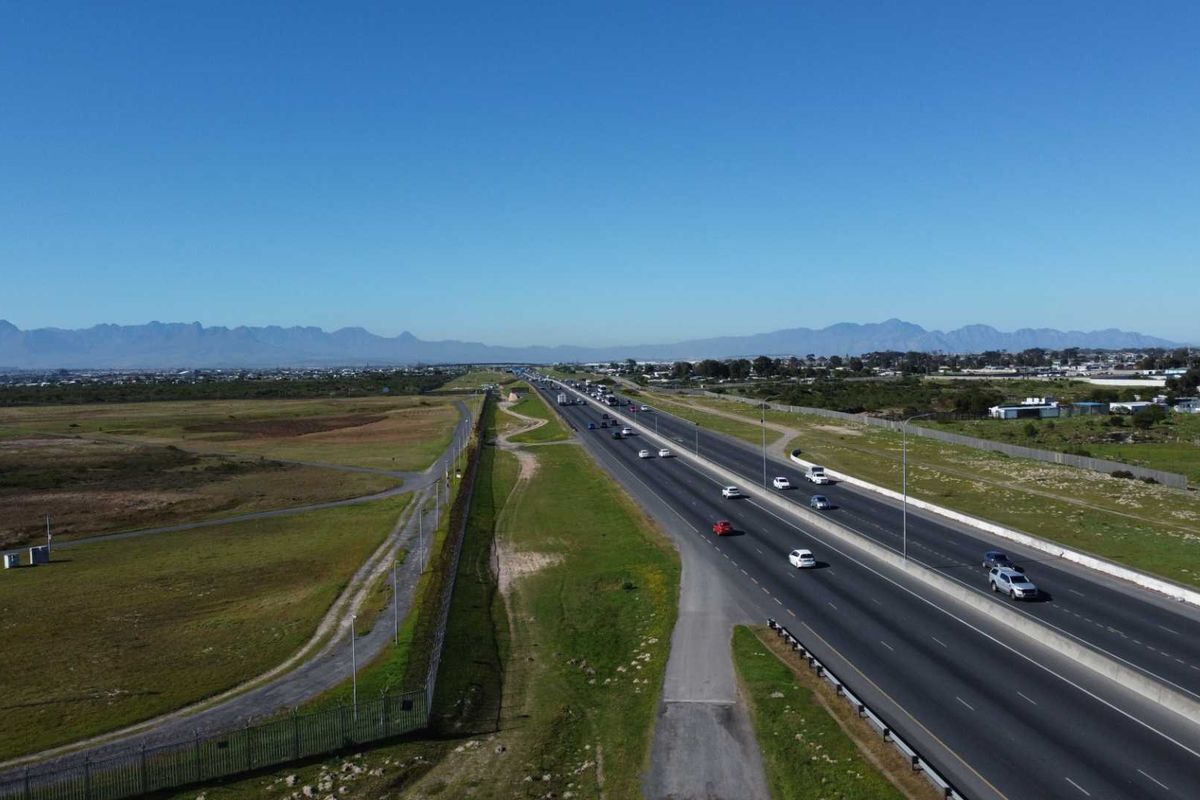 Aerial view of the vacant agricultural land adjacent to a major highway, showcasing the property's location and surrounding landscape.