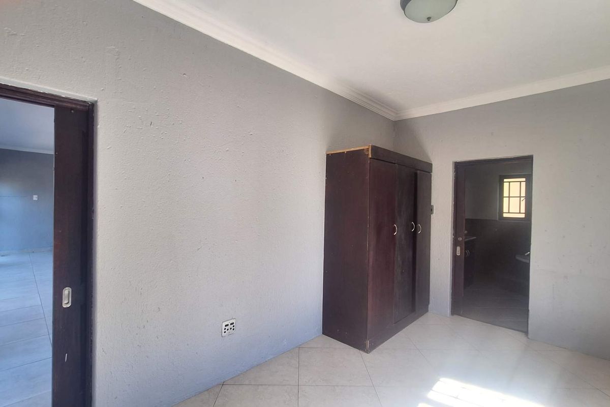 A bedroom featuring tiled flooring and coved ceilings, providing a neutral base for personalization.