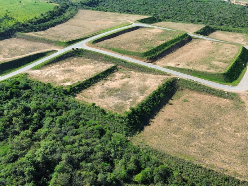 Aerial view of an industrial development site featuring cleared, terraced land plots with established paved access roads and surrounding natural vegetation.