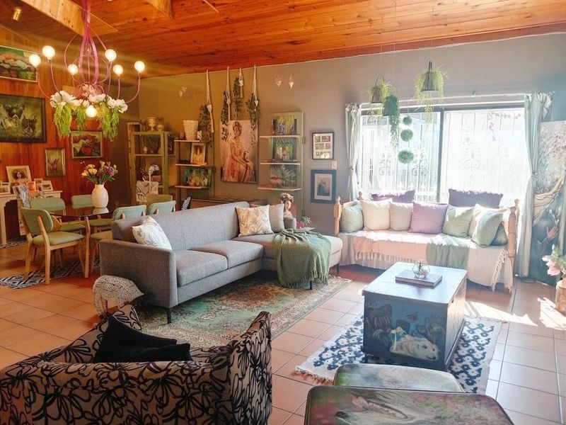 Spacious open-plan living and dining area featuring a warm timber-clad vaulted ceiling, tiled flooring, and large sliding glass doors providing natural light.