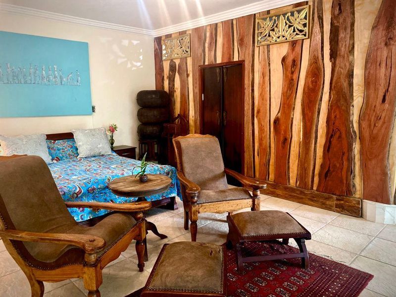 A bedroom featuring distinctive natural wood wall paneling, tiled flooring, and crown molding, offering a unique rustic aesthetic.