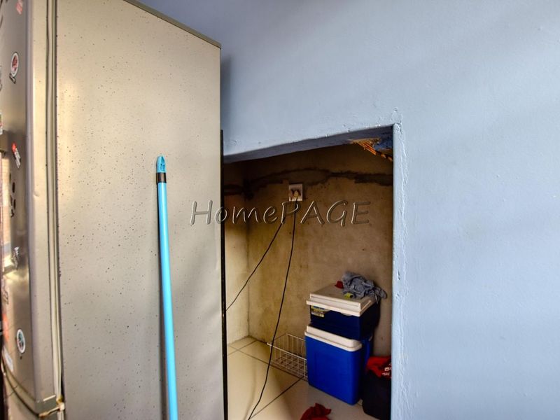 A small utility alcove featuring an electrical outlet, currently showing unfinished wall surfaces and exposed wiring.