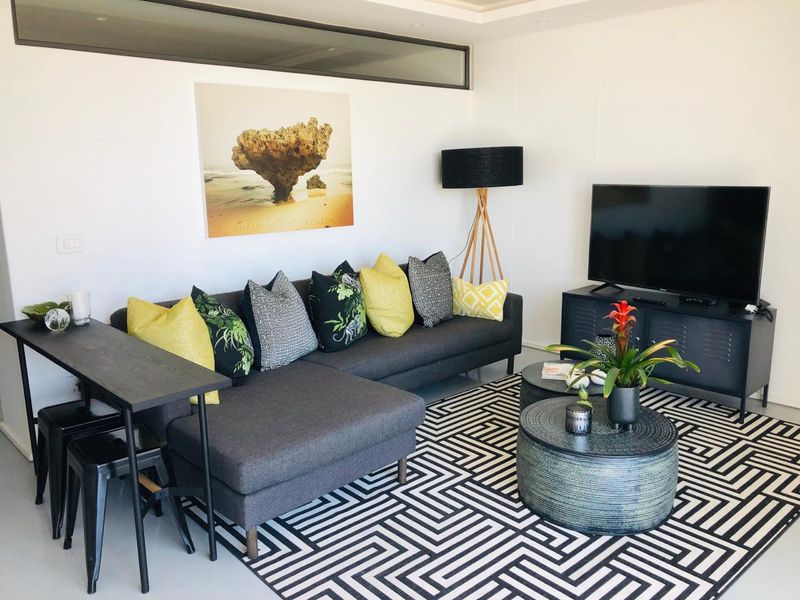 A modern living room featuring a recessed ceiling design and a high-level clerestory window, providing a bright and contemporary atmosphere.