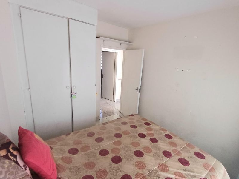 A bedroom featuring a built-in wardrobe and access to an adjacent hallway.