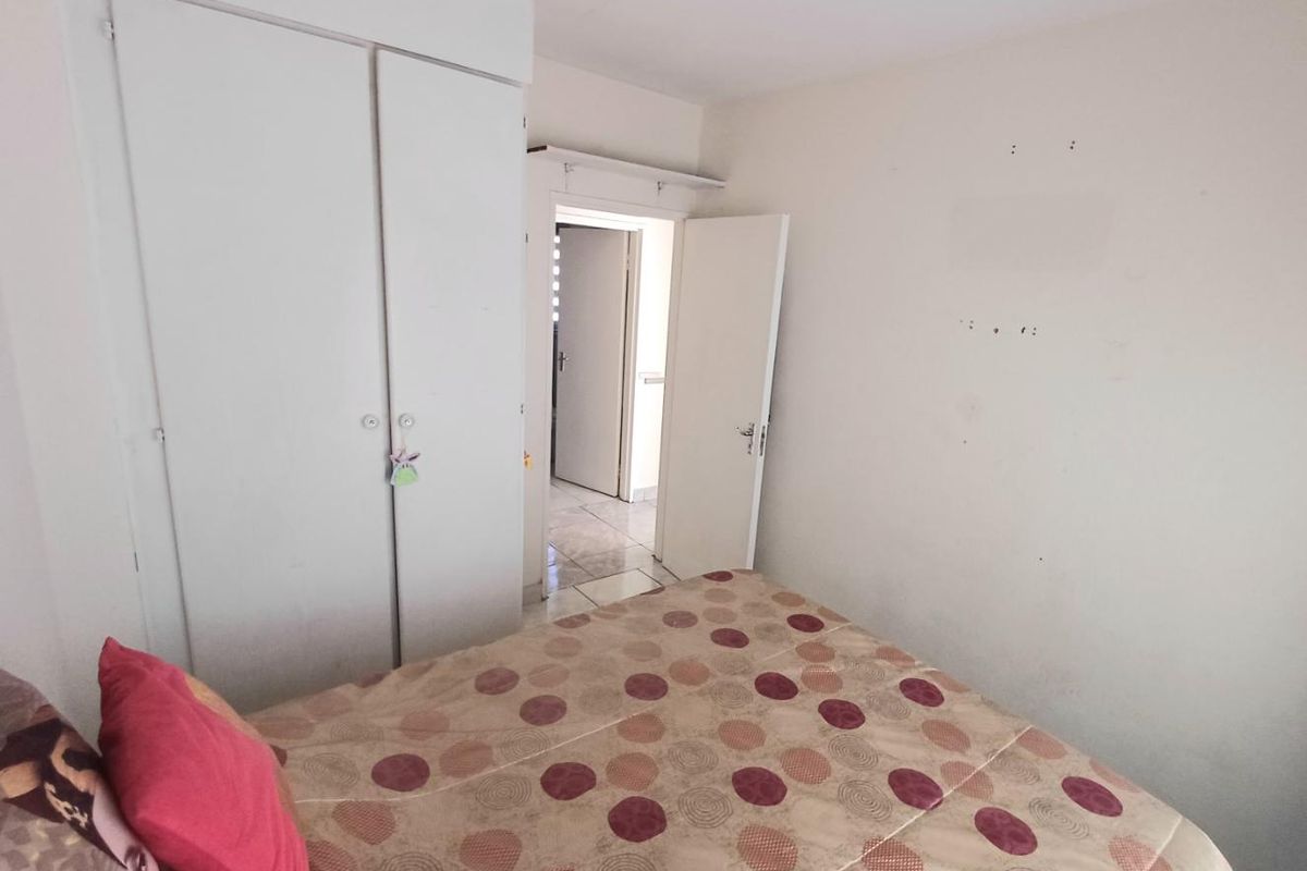 A bedroom featuring a built-in wardrobe and access to an adjacent hallway.