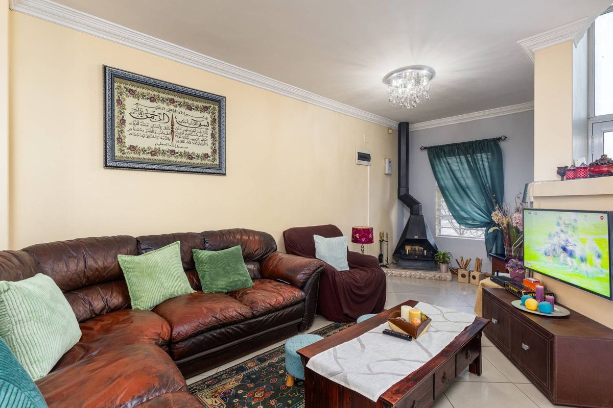A comfortable living room featuring a modern suspended fireplace, tiled flooring, and decorative crown molding.