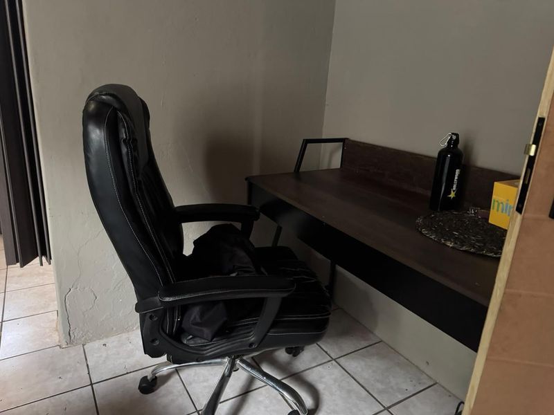 A small home office space featuring tiled flooring and neutral wall finishes, suitable for a compact workspace.
