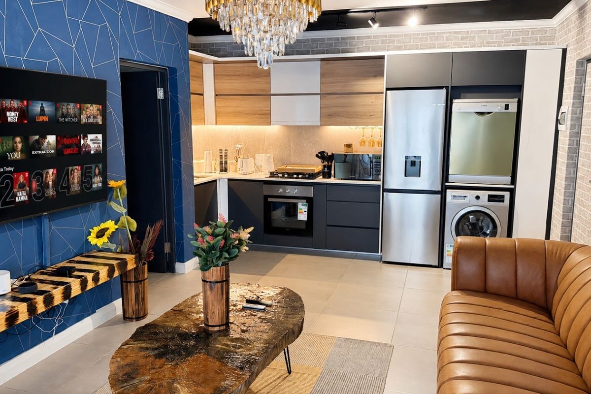 Modern open-plan living area featuring a contemporary kitchen with built-in cabinetry, integrated appliances, and stylish feature walls.