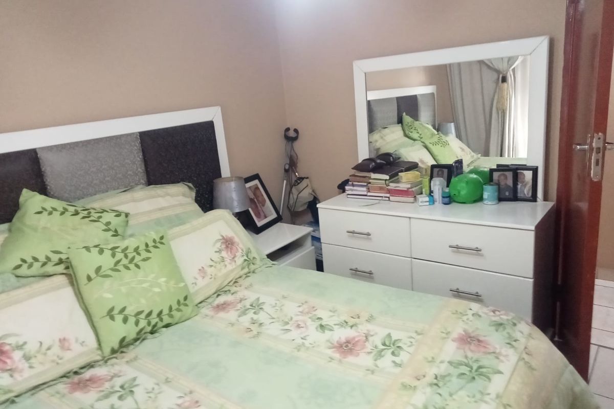 A standard bedroom featuring a built-in headboard and neutral wall finishes, providing a functional space for rest.
