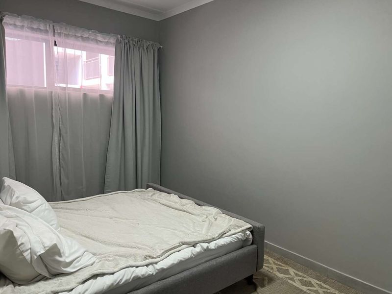 A neutrally painted bedroom featuring coving and skirting boards, providing a clean and simple space.
