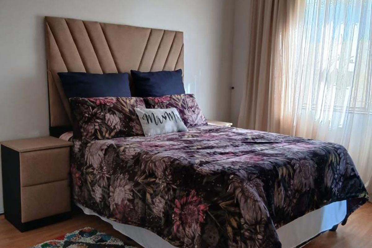 A well-maintained bedroom featuring laminate flooring and neutral wall finishes, providing a comfortable and functional living space.