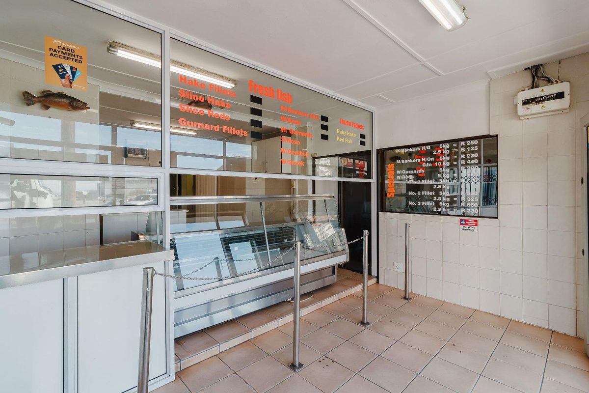 Commercial retail space featuring a refrigerated display counter, tiled surfaces, and glass partitions, suitable for a fresh food or fish market operation.