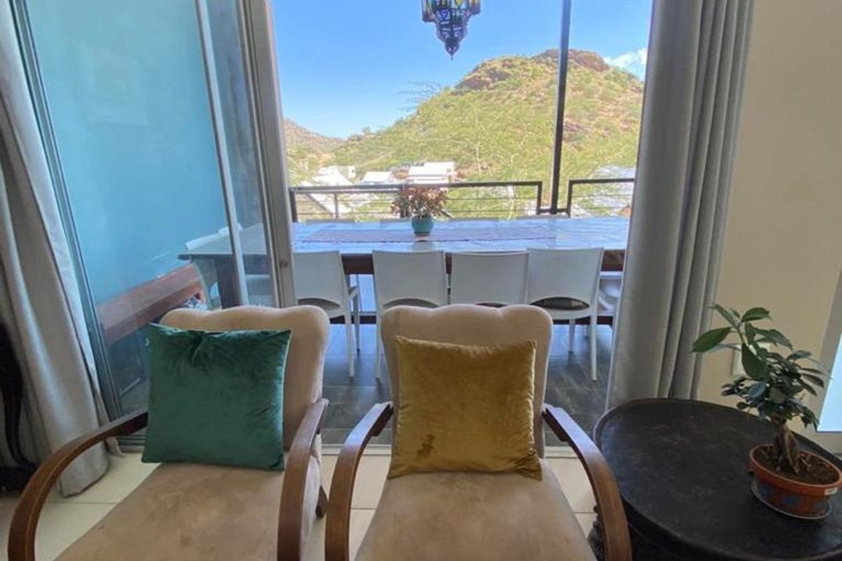 A bright living area featuring large sliding glass doors that open onto a covered patio with scenic mountain views.