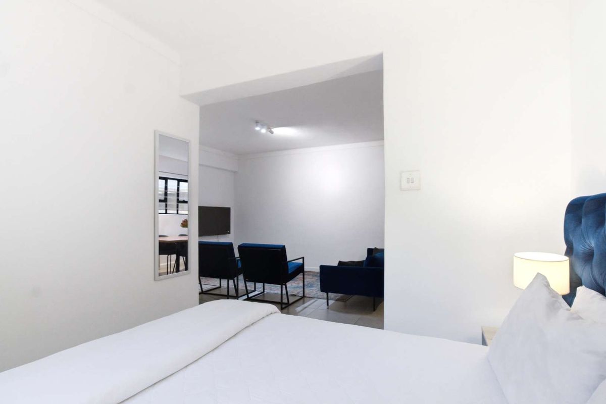A view from the bedroom looking into the adjacent living area, featuring neutral finishes and a clean, open-plan layout.