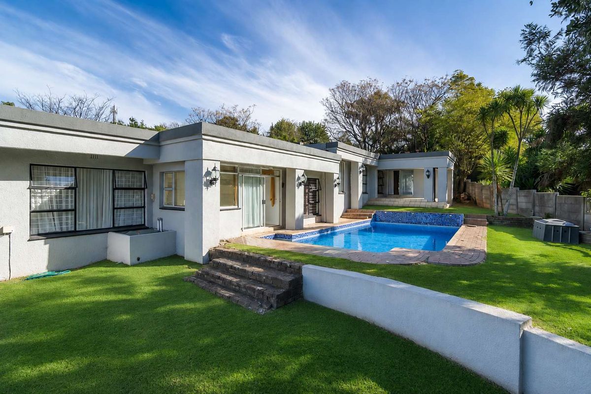 Rear view of the property featuring a swimming pool, landscaped lawn, brick steps, and direct access to the home via sliding glass doors.