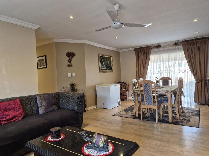 Open-plan living and dining area featuring laminate flooring, recessed lighting, a ceiling fan, and access to the exterior via a sliding glass door.