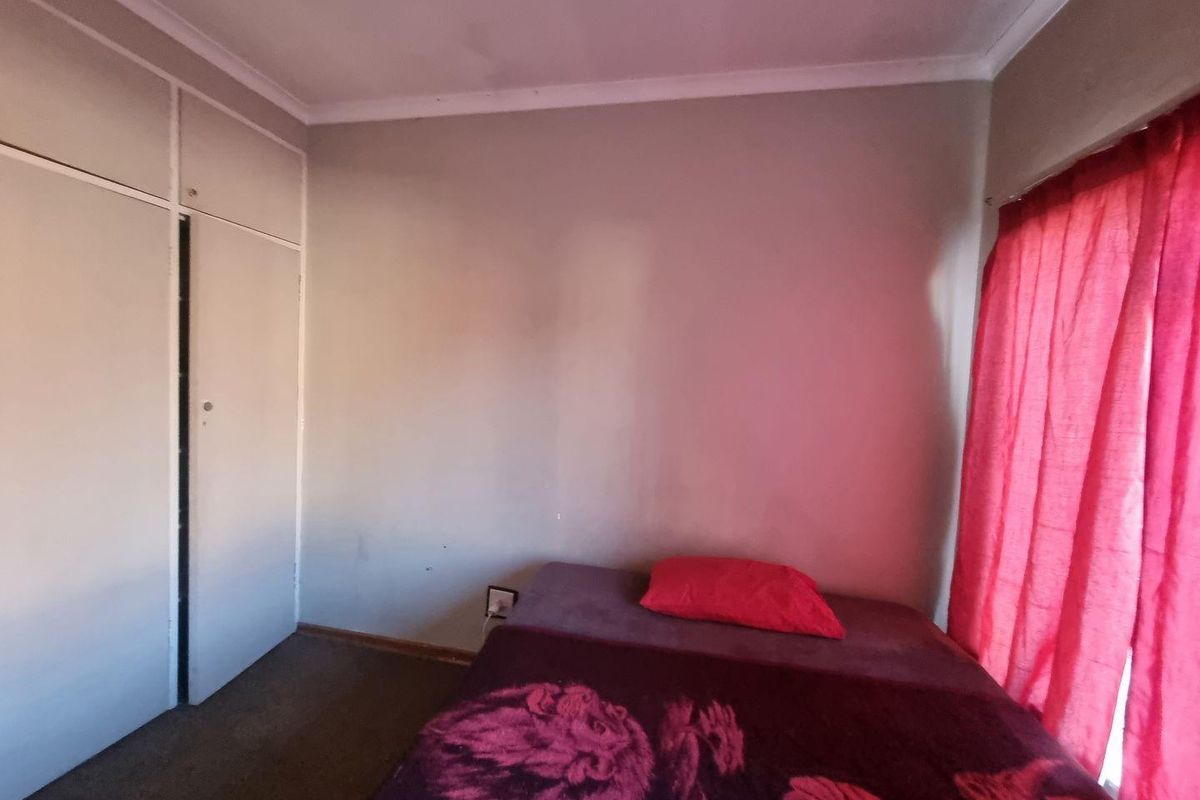 A bedroom featuring built-in cupboards and coving, requiring cosmetic updates to improve the overall aesthetic and condition of the space.