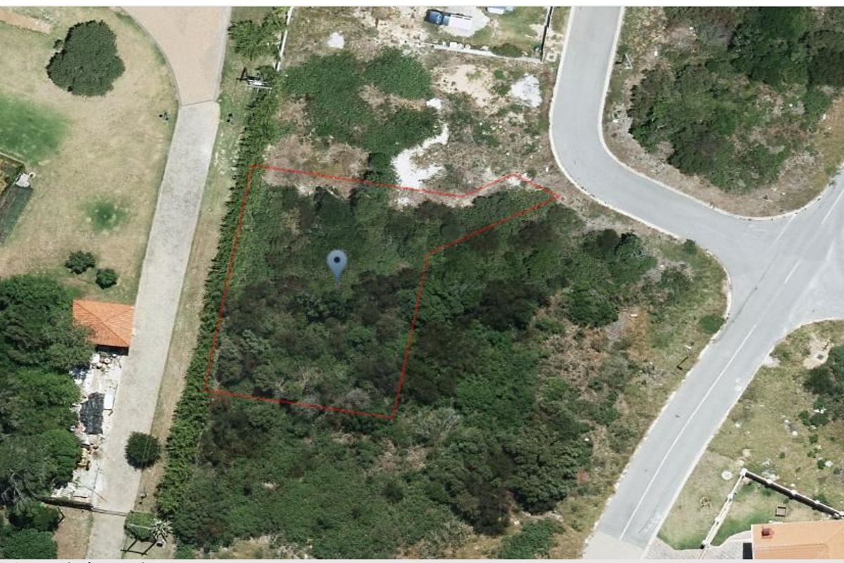 An aerial view of a vacant residential plot, showing the property boundaries and surrounding neighborhood infrastructure.