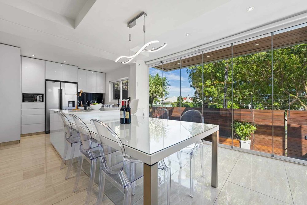 Kitchen and glass stacking doors opening onto swimming pool