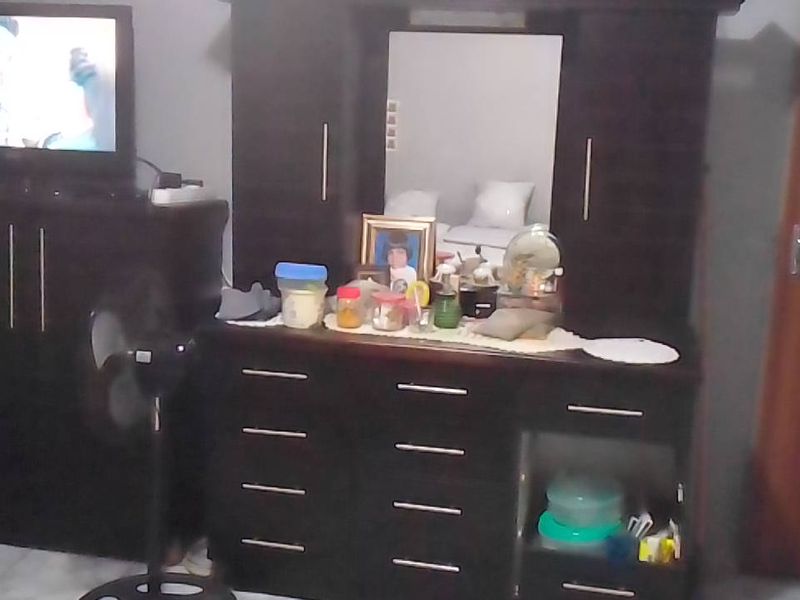 A bedroom featuring a built-in wardrobe and a standard internal door, providing functional storage and access within the room.