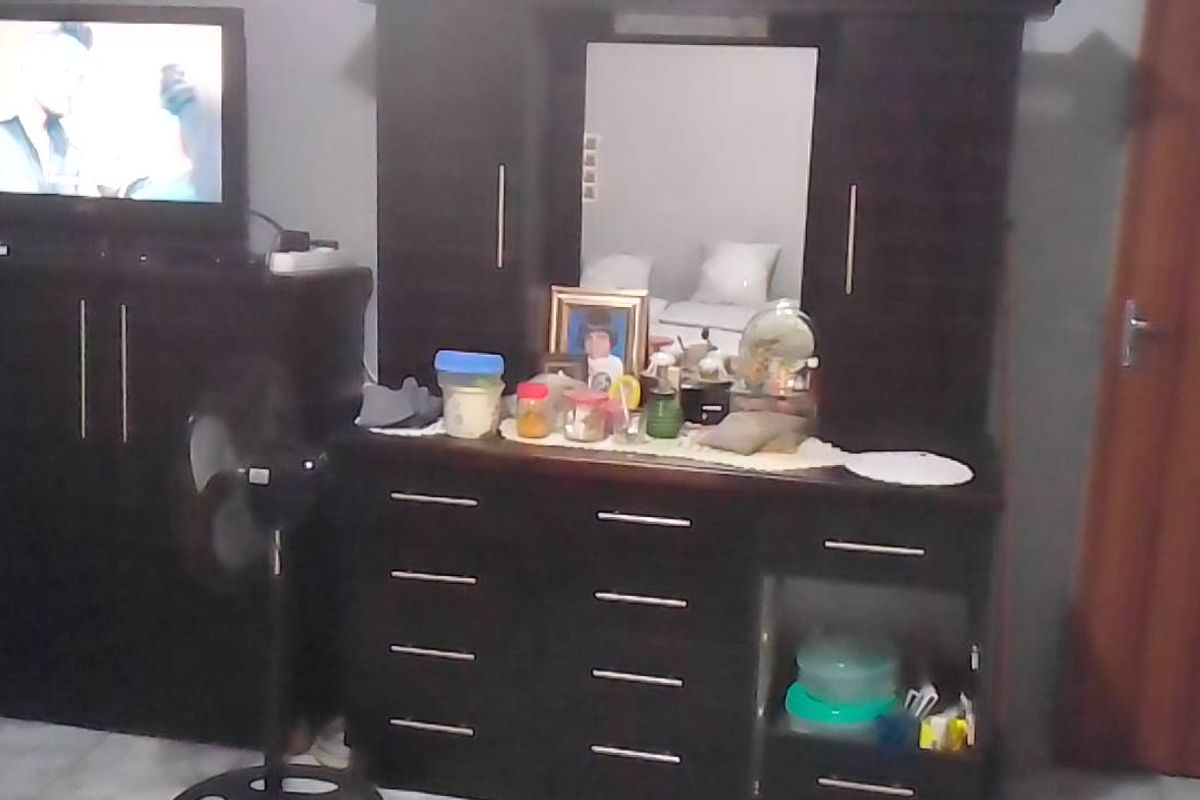 A bedroom featuring a built-in wardrobe and a standard internal door, providing functional storage and access within the room.